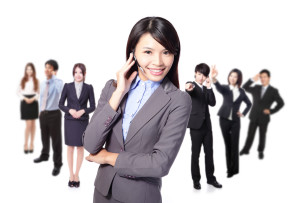 Smiling call center executive with colleagues